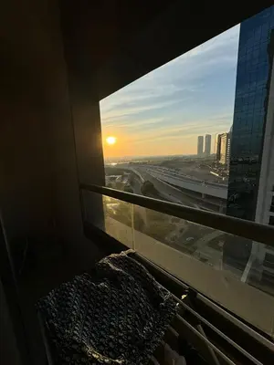 a view of the sunset from a window in a building at Bright and Airy 2BR Bay Retreat in Dubai