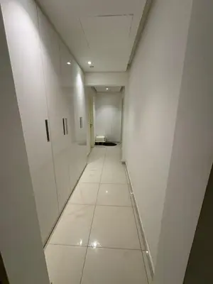 a long hallway with white walls and a white tile floor at Bright and Airy 2BR Bay Retreat in Dubai