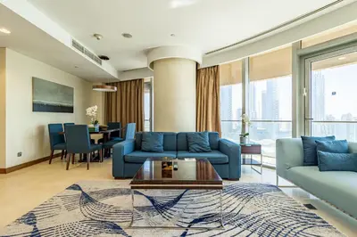 a living room with blue couches and a table at SuperHost EMAAR Residences - Former Address Dubai Mall in Dubai