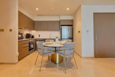 a kitchen with a table and chairs in a room at Downtown Luxury 2BR - Full Burj Khalifa & Fountain Views - 5 Minutes Walk to Dubai Mall in Dubai