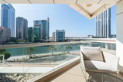 a balcony with a chair and a view of the city at Stylish 1-Bedroom with Stunning Marina Views at Dorra Bay in Dubai