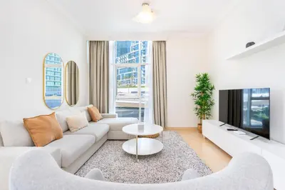 a living room with a couch and a table at Stylish 1-Bedroom with Stunning Marina Views at Dorra Bay in Dubai