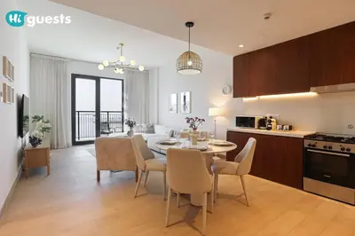 a kitchen and living room with a table and chairs at HiGuest - Elegant 1BR Oasis in La Mer in Dubai