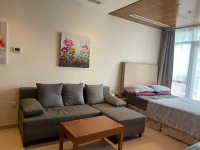 a living room with a couch and a bed at Cozy Studio in Dubai