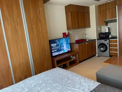 a small kitchen with a television in a room at Cozy Studio in Dubai