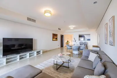 a living room with a couch and a tv at Balqis I Renovated 3BDR with 1 maid room I Palm Jumeirah in Dubai