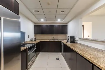 a kitchen with stainless steel appliances and brown cabinets at Balqis I Renovated 3BDR with 1 maid room I Palm Jumeirah in Dubai