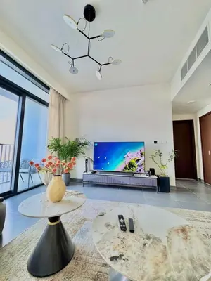 a living room with a flat screen tv and a table at Creek edge,1 bedroom apartment, creek Harbour, high Floor in Dubai