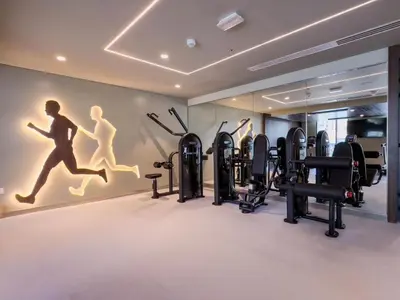a gym with cardio equipment and a wall with a mural at Creek edge,1 bedroom apartment, creek Harbour, high Floor in Dubai