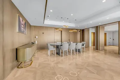 a dining room with a table and white chairs at luxury penthouses see view at five in Dubai