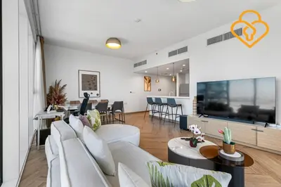 a living room with white furniture and a large screen tv at Keysplease 2BR Minutes to WTC and Downtown, Al Wasl Zaabeel Park in Dubai