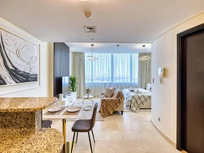 a living room with a table and a living room at Classic Sky Studio Bright in Dubai