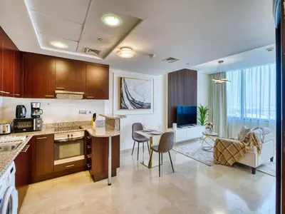 a kitchen and living room with a table and chairs at Classic Sky Studio Bright in Dubai