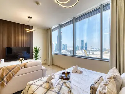a bedroom with a couch and a large window at Classic Sky Studio Bright in Dubai