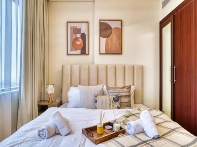 a bedroom with a bed with a tray on it at Classic Sky Studio Bright in Dubai