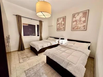 a bedroom with two beds and a window at Cozy Family-Friendly 2BR in JVT in Dubai