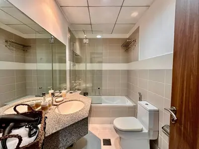 a bathroom with a sink and a toilet and a tub at Cozy Family-Friendly 2BR in JVT in Dubai
