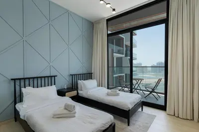 a hotel room with two beds and a balcony at Stylish 3 Bedroom in JVC in Dubai