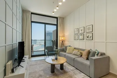 a living room with a couch and a tv at Stylish 3 Bedroom in JVC in Dubai