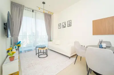 a white living room with a couch and a table at AWS Holiday Homes - Perfect Dubai Stay! in Dubai