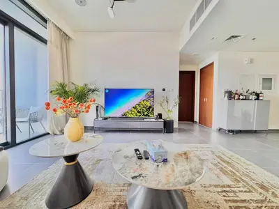a living room with a tv and a table at Creek edge,1 bedroom apartment, creek Harbour, high Floor in Dubai