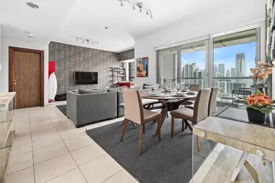 a living room with a dining table and a couch at 3BR plus Maid Executive Tower L, City View in Dubai