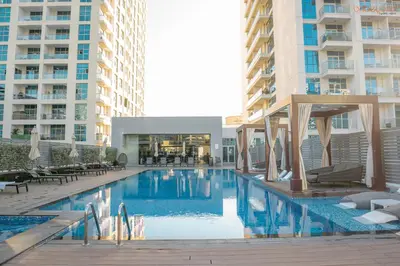 a swimming pool in a hotel with two tall buildings at Bnbeyond's Sheek Studio at Studio One tower in Dubai