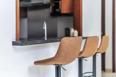 a couple of chairs sitting next to a kitchen counter at GuestReady - Luxe 1BD Near Dubai Mall | 29 Blvd in Dubai