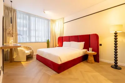 a bedroom with a large bed with a red headboard at Stylish Luxury in the Heart of DIFC in Dubai