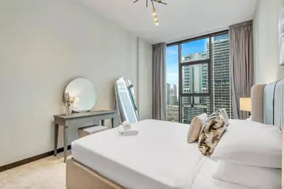 a bedroom with a bed and a mirror and a window at GuestReady - Stylish haven with lake views in Dubai