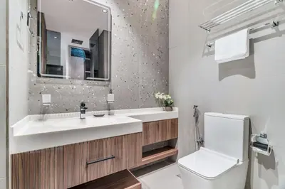 a bathroom with a sink and a toilet and a mirror at GuestReady - Stylish haven with lake views in Dubai