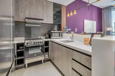 a kitchen with purple walls and stainless steel appliances at GuestReady - Stylish haven with lake views in Dubai