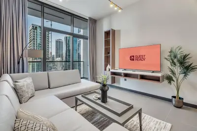 a living room with a couch and a tv at GuestReady - Stylish haven with lake views in Dubai
