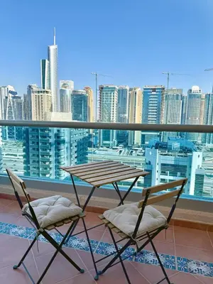 a table and chairs on a balcony with a view of a city at One Bedroom Apt in Dubai Marina near beach Z1911 in Dubai