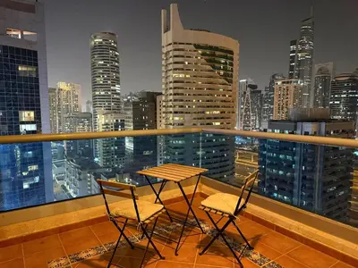 a table and chairs on a balcony with a city skyline at One Bedroom Apt in Dubai Marina near beach Z1911 in Dubai