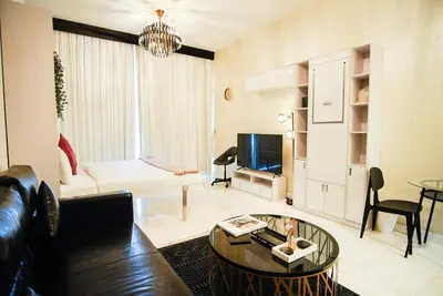 a living room with a couch and a table at Luxury Studio Bayz By Danube Business Bay Marasi Drive Dubai in Dubai