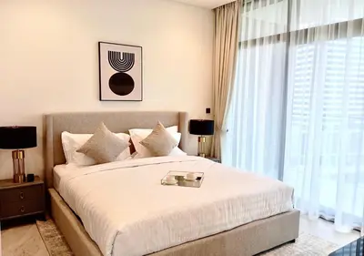 a bedroom with a large bed with a large window at Bespoke Holiday Homes - Luxury 1BR in High Floor with Stunning Canal Views in Dubai
