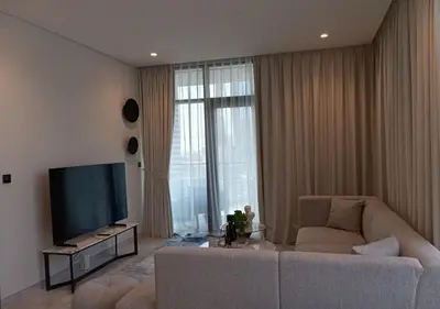 a living room with a couch and a flat screen tv at Bespoke Holiday Homes - Luxury 1BR in High Floor with Stunning Canal Views in Dubai