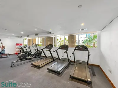 a gym with rows of tread machines in a room at Serene 1 Bedroom apartment in Belgravia - JVC in Dubai