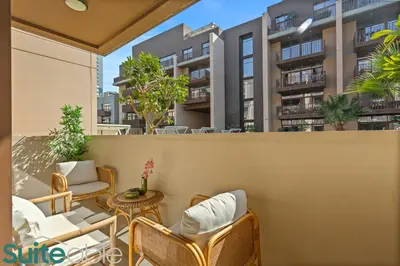 a balcony with chairs and tables and buildings at Serene 1 Bedroom apartment in Belgravia - JVC in Dubai