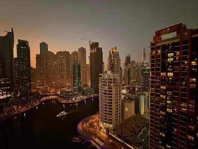 a city skyline at night with a river and buildings at JW Marriott Stylish 1BR - Marina View - Direct Dubai Marina Mall Access - Pool & Gym - Free Parking in Dubai