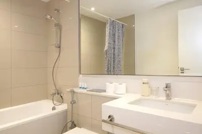 a bathroom with a sink and a tub and a mirror at Park Point C-1 bedroom for monthly stay-1004 in Dubai