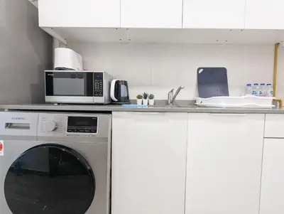 a kitchen with a microwave and a dishwasher at Fully Furnished Cozy Studio at JVC Dubai, Short Drive to Dubai Marina, JBR, Downtown Dubai in Dubai