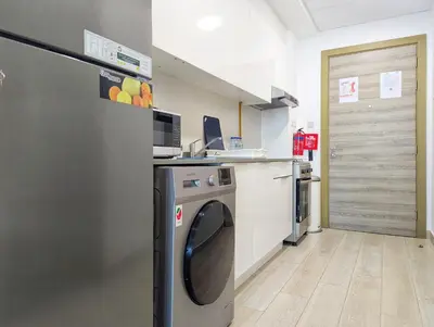 a laundry room with a washer and dryer at Fully Furnished Cozy Studio at JVC Dubai, Short Drive to Dubai Marina, JBR, Downtown Dubai in Dubai