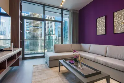 a living room with purple walls and a couch at MBL Royal, JLT- 1-BR Apartment with Lake View in Dubai