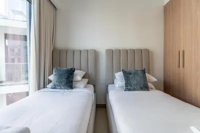 two beds sitting next to a window in a room at GuestReady - Contemporary retreat at Azizi Gardens in Dubai