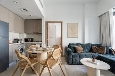 a living room with a blue couch and a table at GuestReady - Contemporary retreat at Azizi Gardens in Dubai