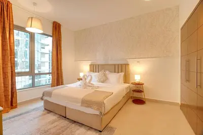 a bedroom with a bed and a large window at Luxury Living Brand New 1 Bed Downtown Dubai Southridge in Dubai