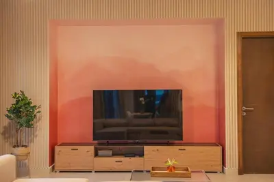a living room with a flat screen tv on a wall at Luxury Living Brand New 1 Bed Downtown Dubai Southridge in Dubai