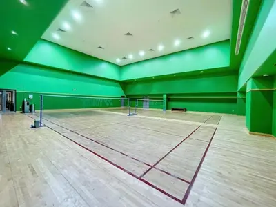 a tennis court with a net in a room with green walls at Luxury Living Brand New 1 Bed Downtown Dubai Southridge in Dubai
